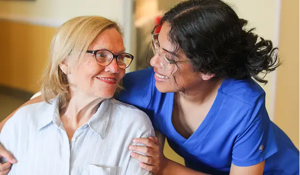 Staff member interacting with a resident in a warm setting