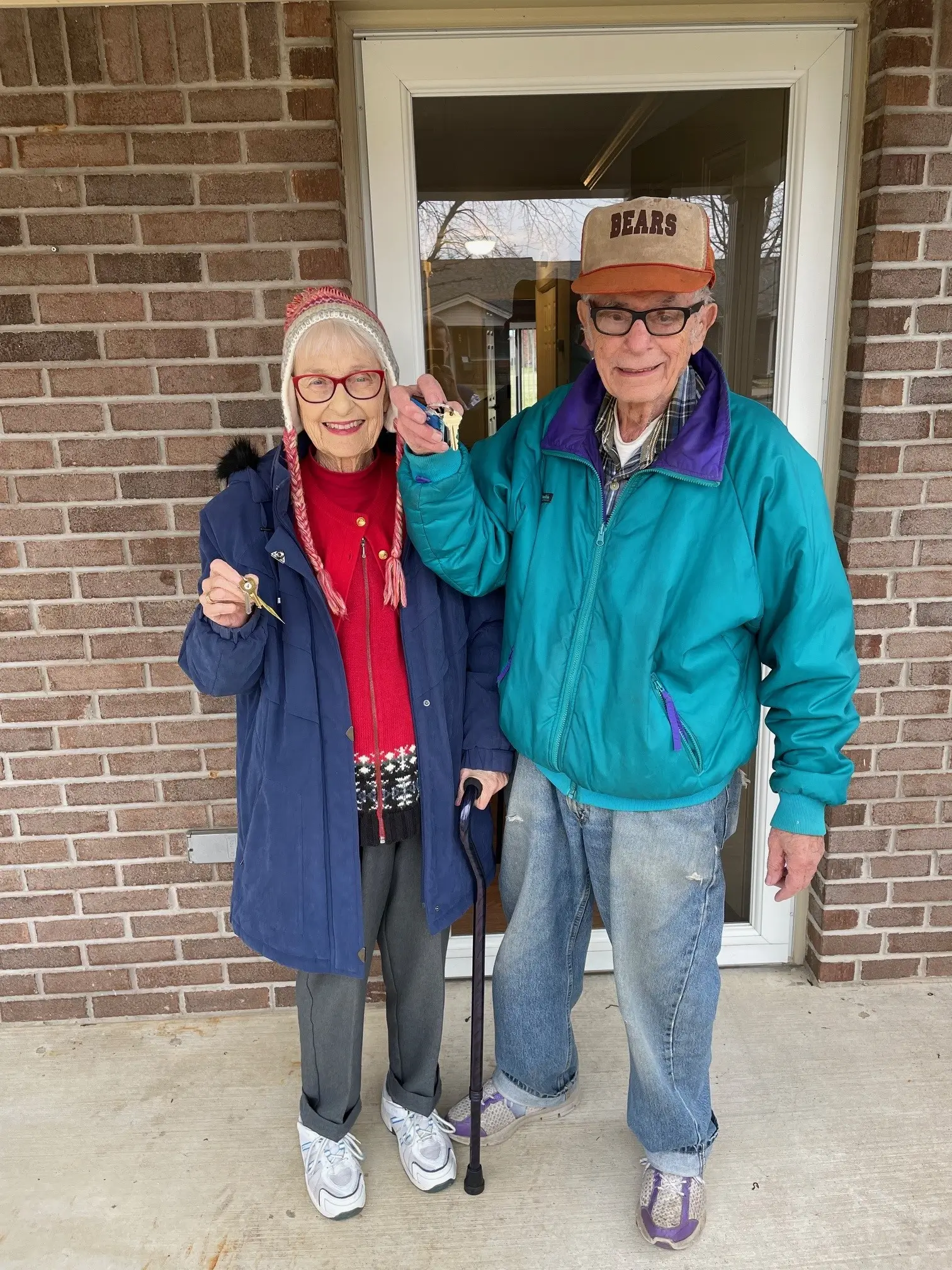 Two residents holding keys outside the facility entrance