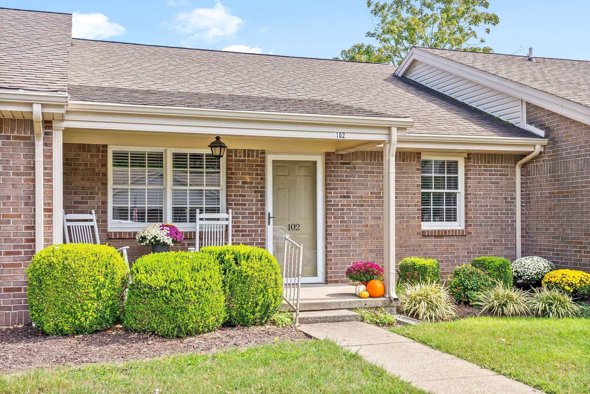 Welcoming entrance of a senior living residence with flowers