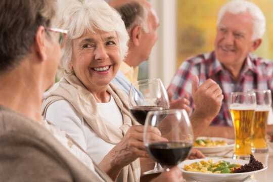 Residents enjoying a meal and toasting with drinks