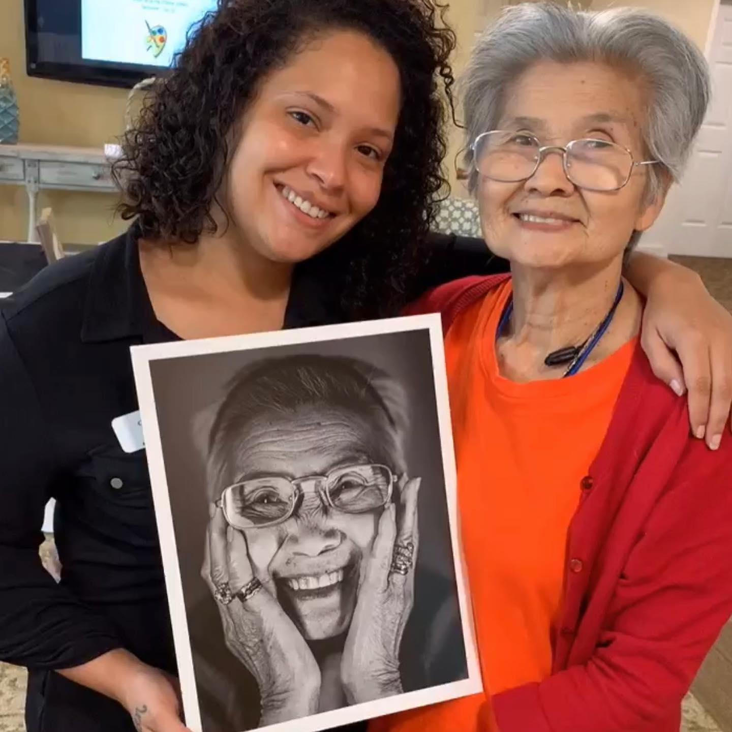 Staff member and resident smiling together indoors