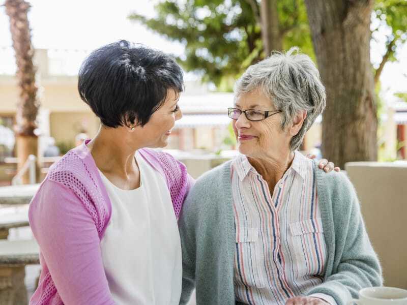 A caregiver and resident sharing a warm moment outdoors