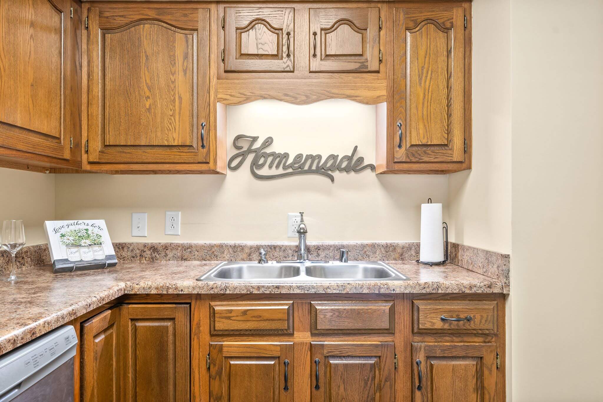 Cozy kitchen area with wooden cabinets and homemade sign