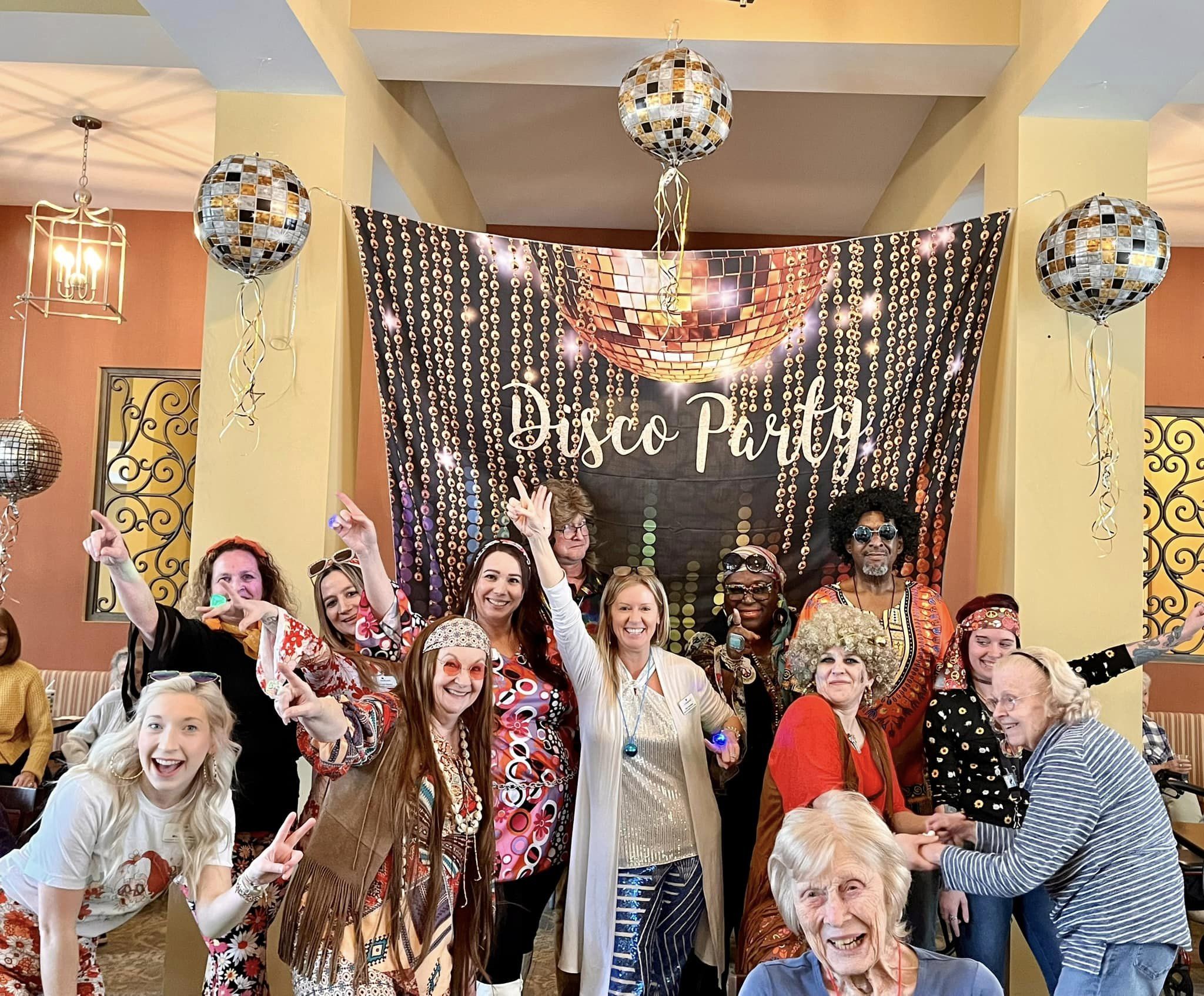 Residents and staff enjoying a disco-themed party