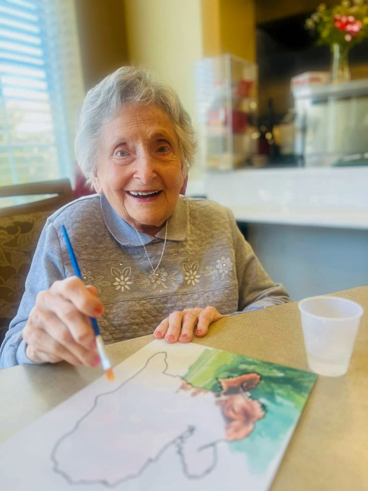 Senior resident painting in an activity room