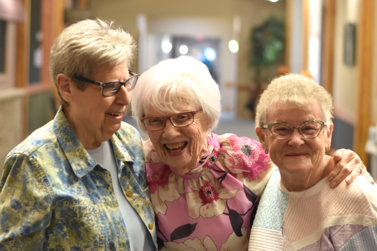Three smiling residents in a hallway