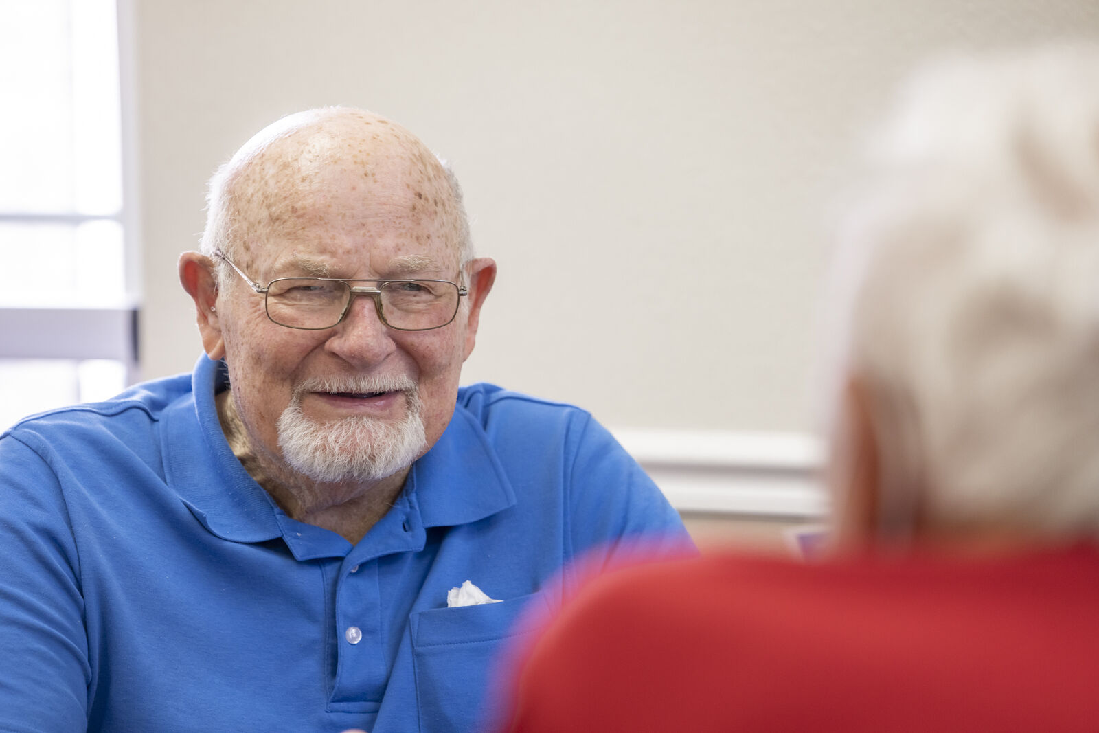 Senior man smiling while engaging in conversation