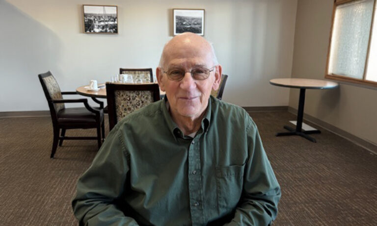 A resident smiling in the common area of the facility