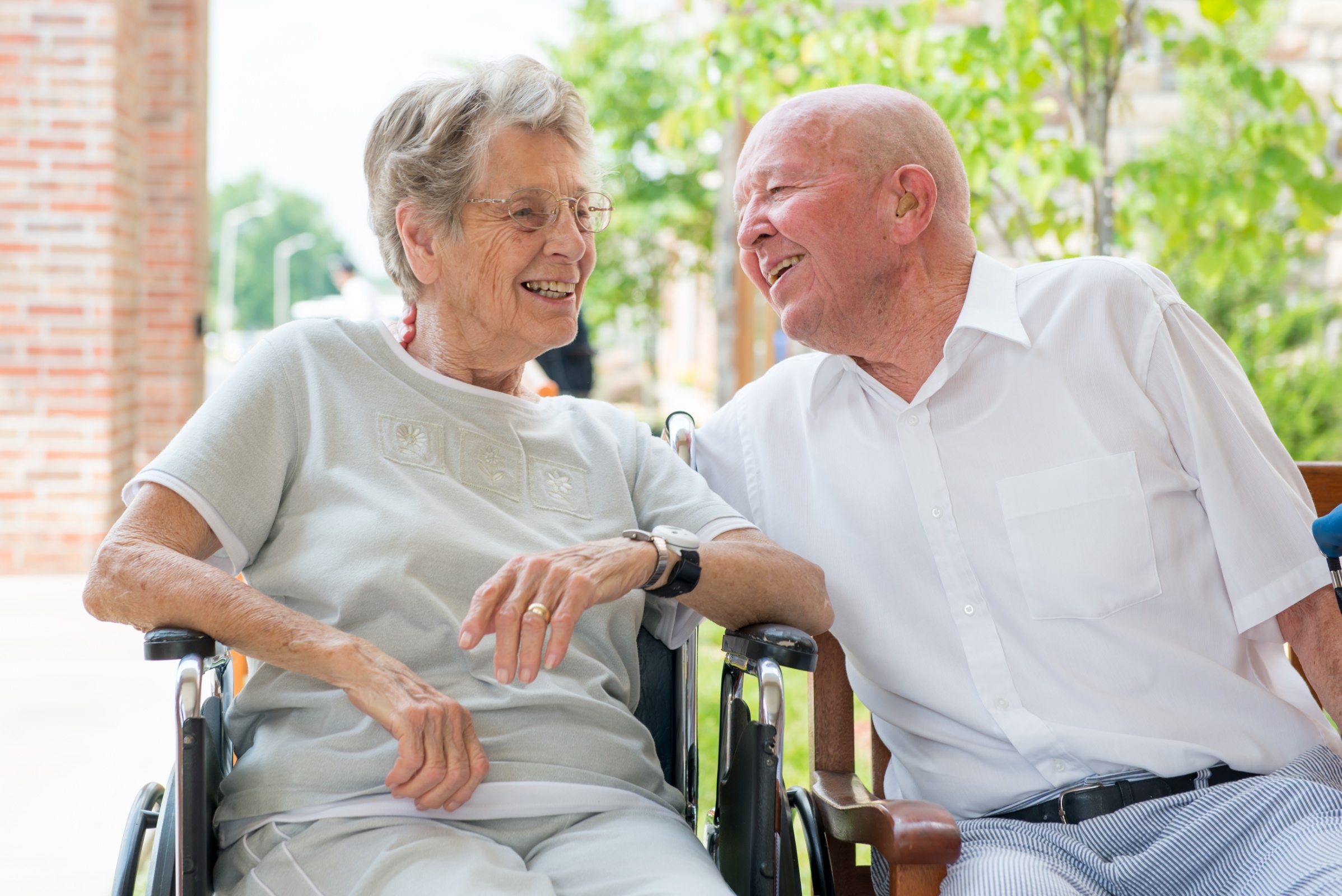 Two residents laughing together outdoors in a garden