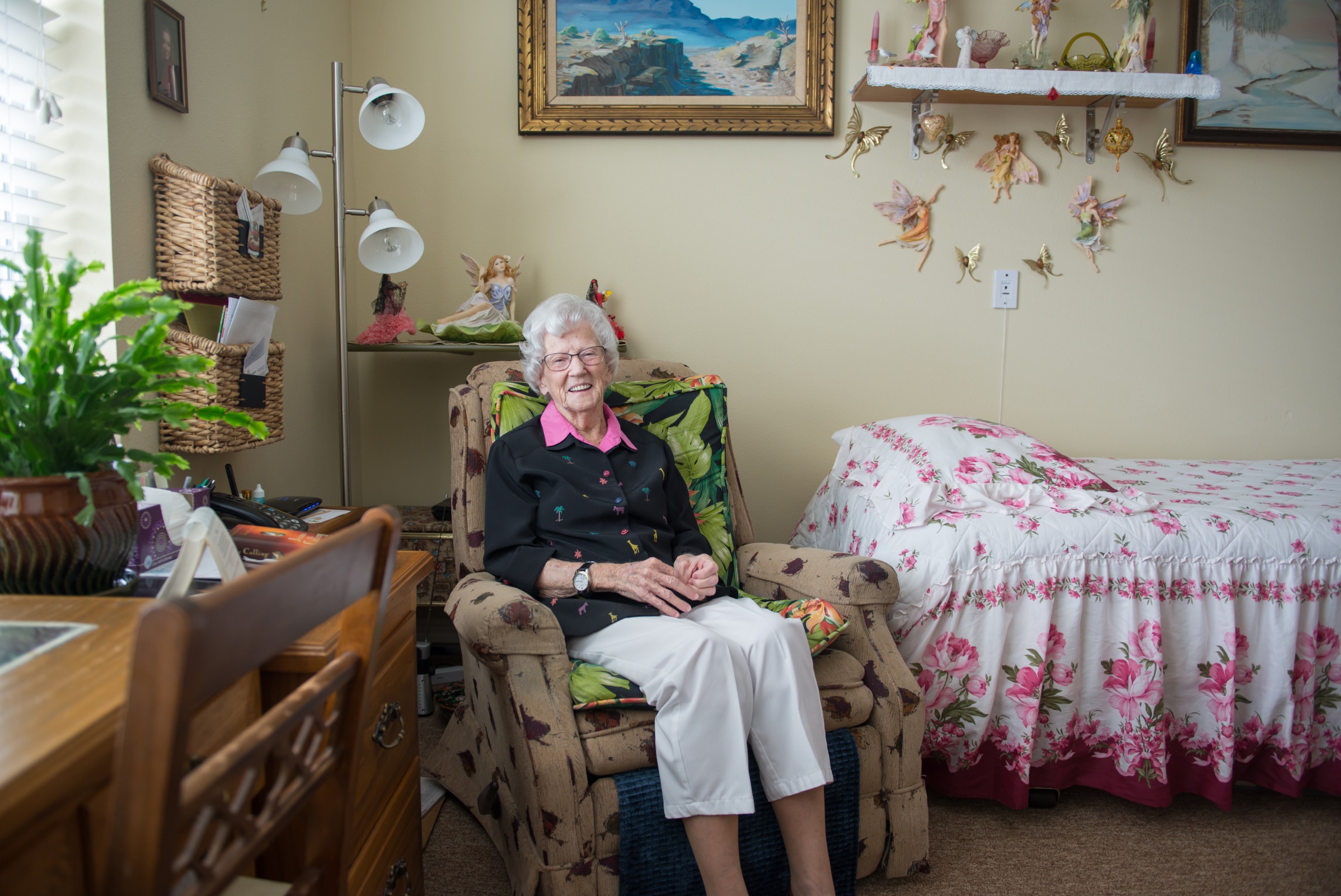 An elderly woman sitting in a comfortable chair in her room