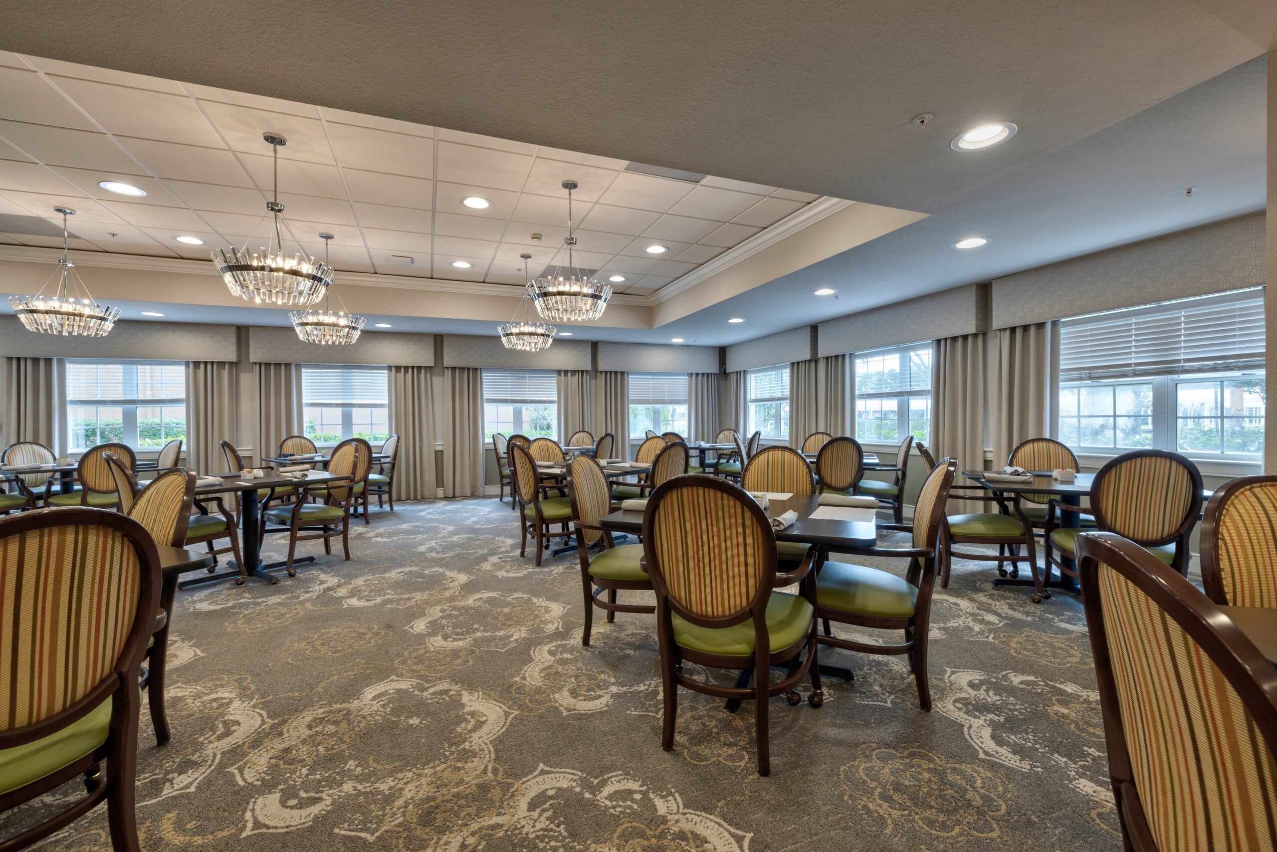 Bright dining room with elegant chandeliers and seating