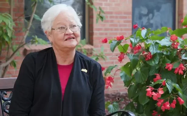 Resident enjoying a garden space with flowers