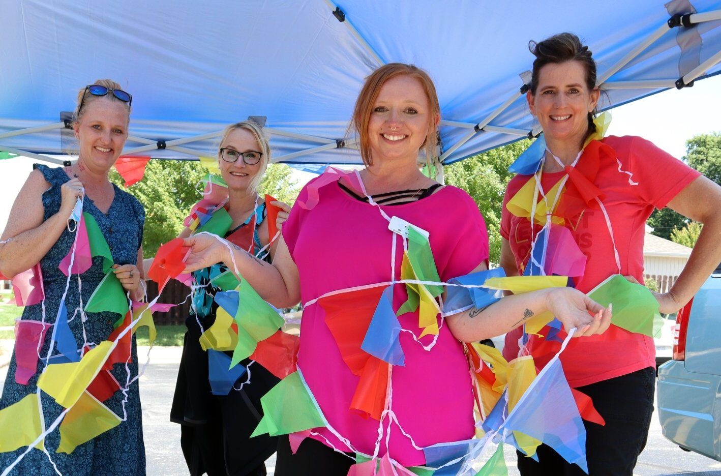Staff celebrating with colorful flags outdoors