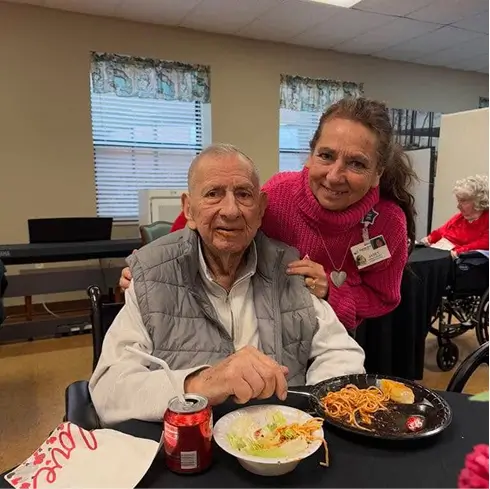 Resident enjoying a meal with staff member