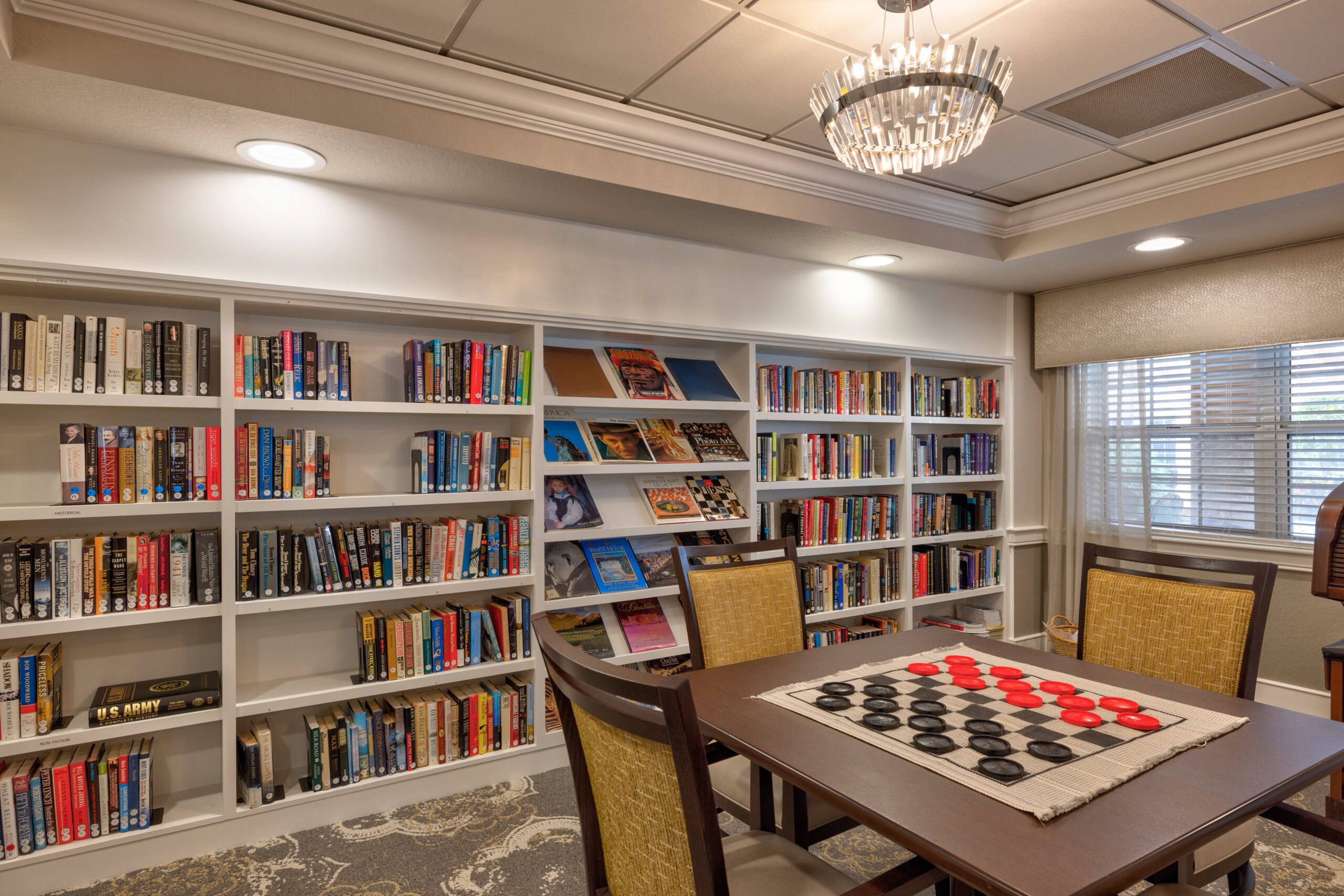 Interior view of a library with books and a checkers board