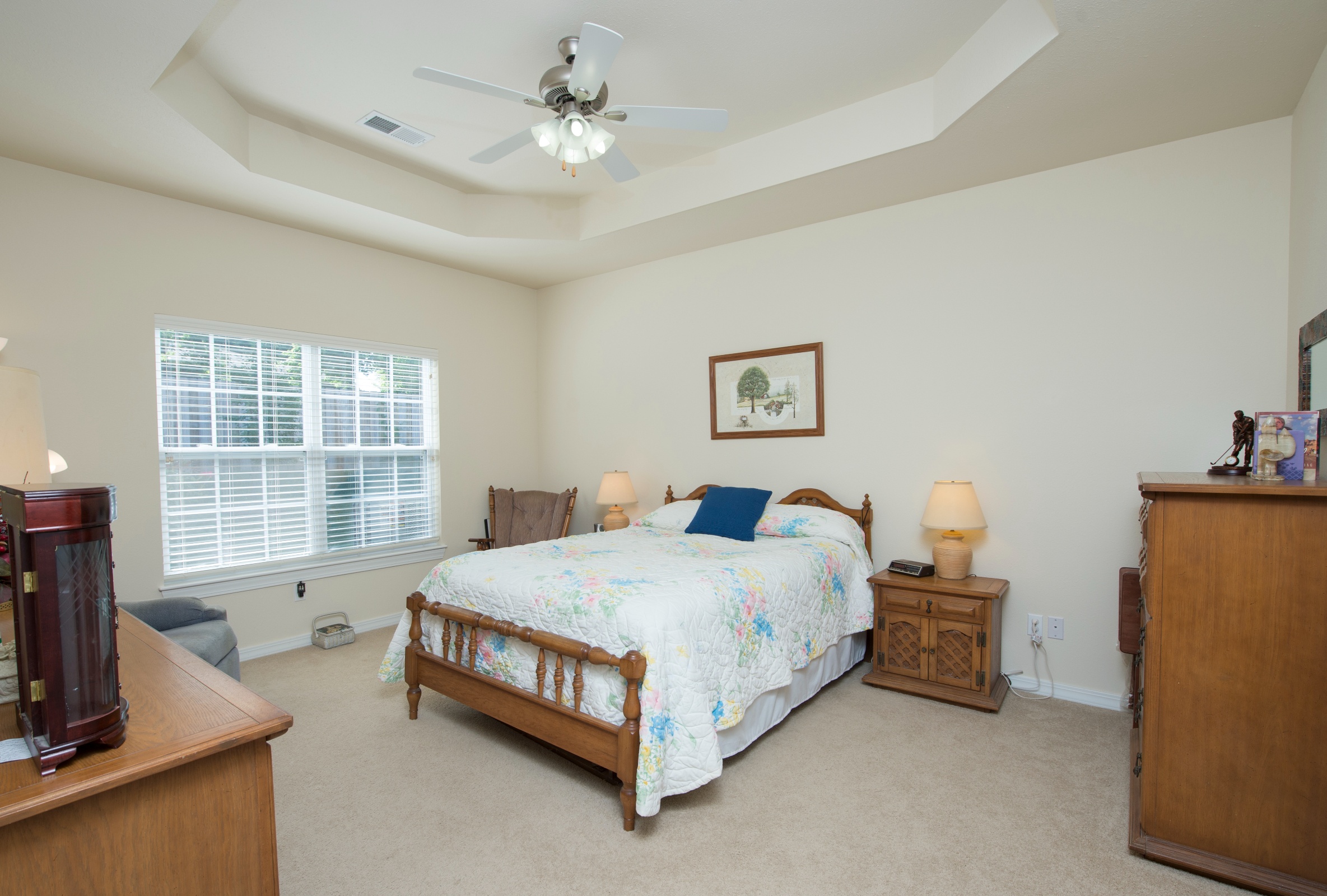 Well-lit private resident room with a bed and furniture