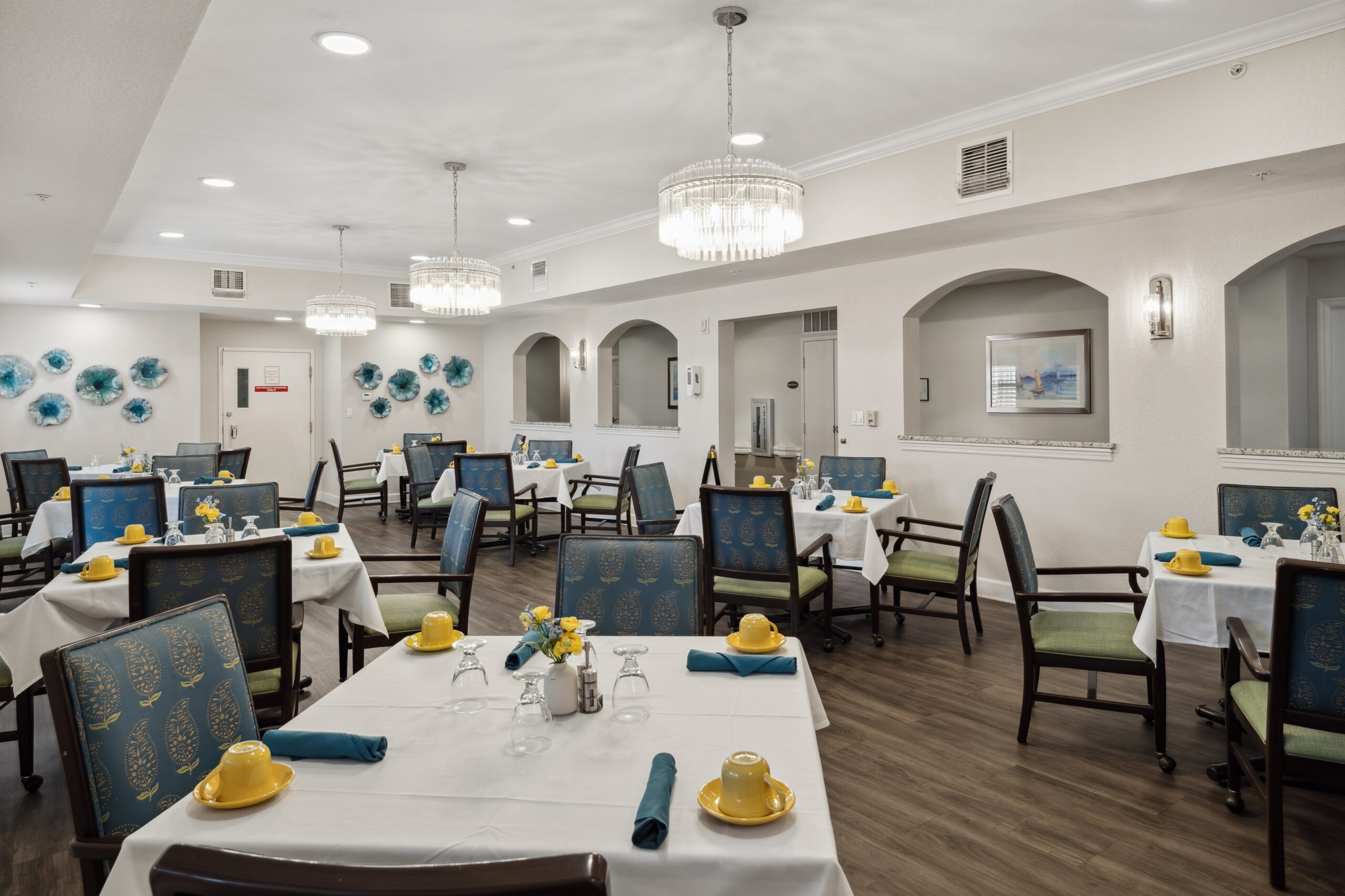 Bright dining room setup with tables and flowers