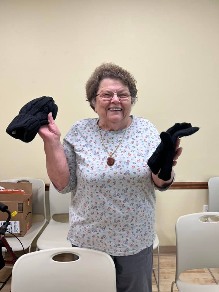 Resident joyfully holding gloves in the activity room
