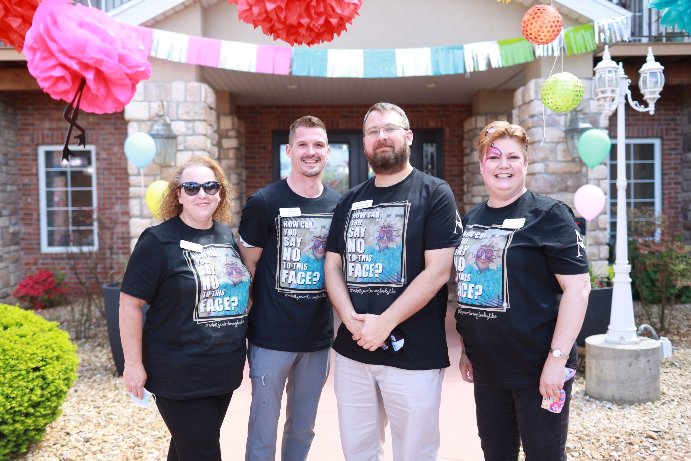 Staff and residents celebrating in front of the facility
