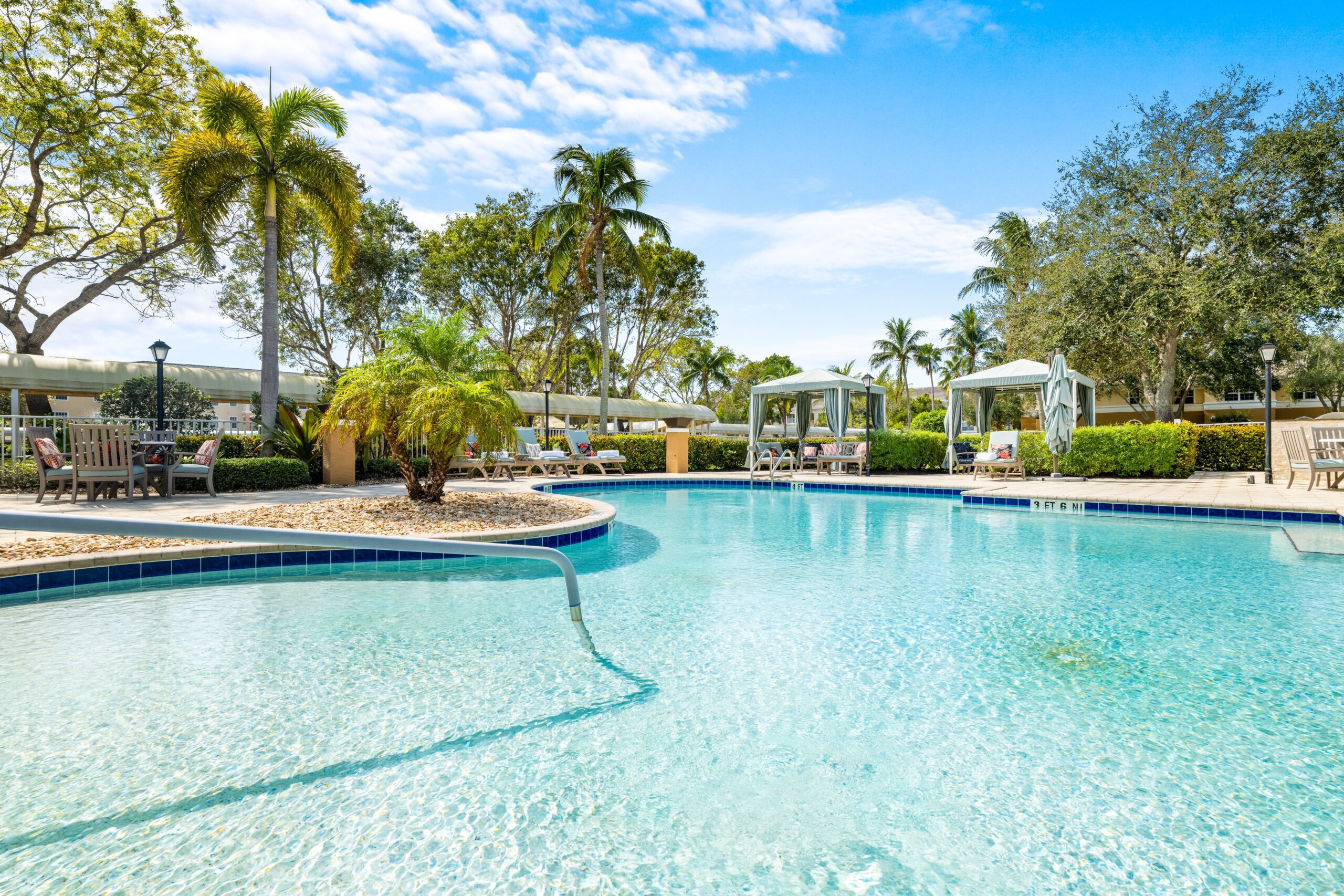 Beautiful outdoor pool area with lounge chairs and cabanas