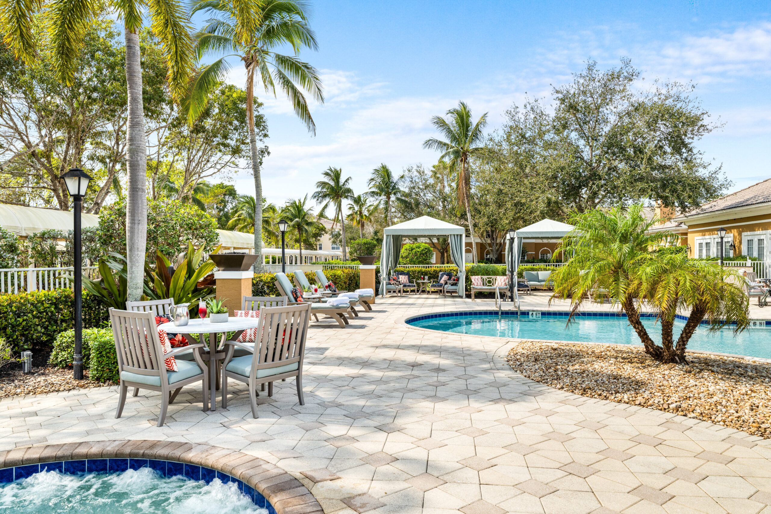 Outdoor pool area with lounge chairs and cabanas