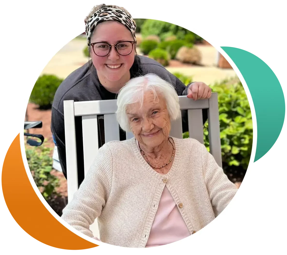 A staff member posing with a resident in a garden