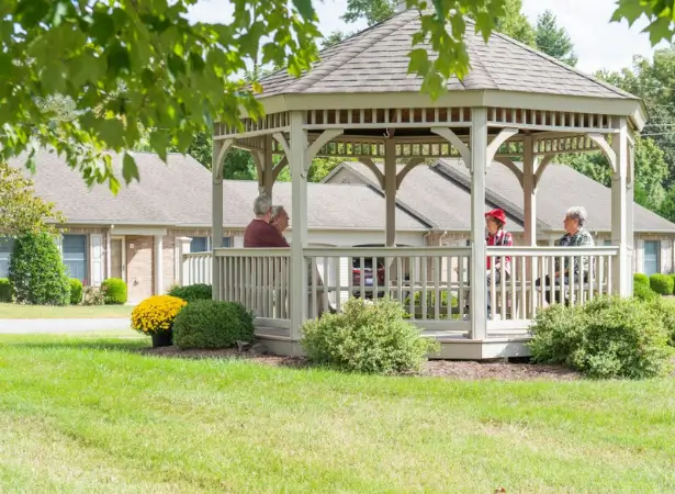Residents relaxing in a gazebo in the facility garden