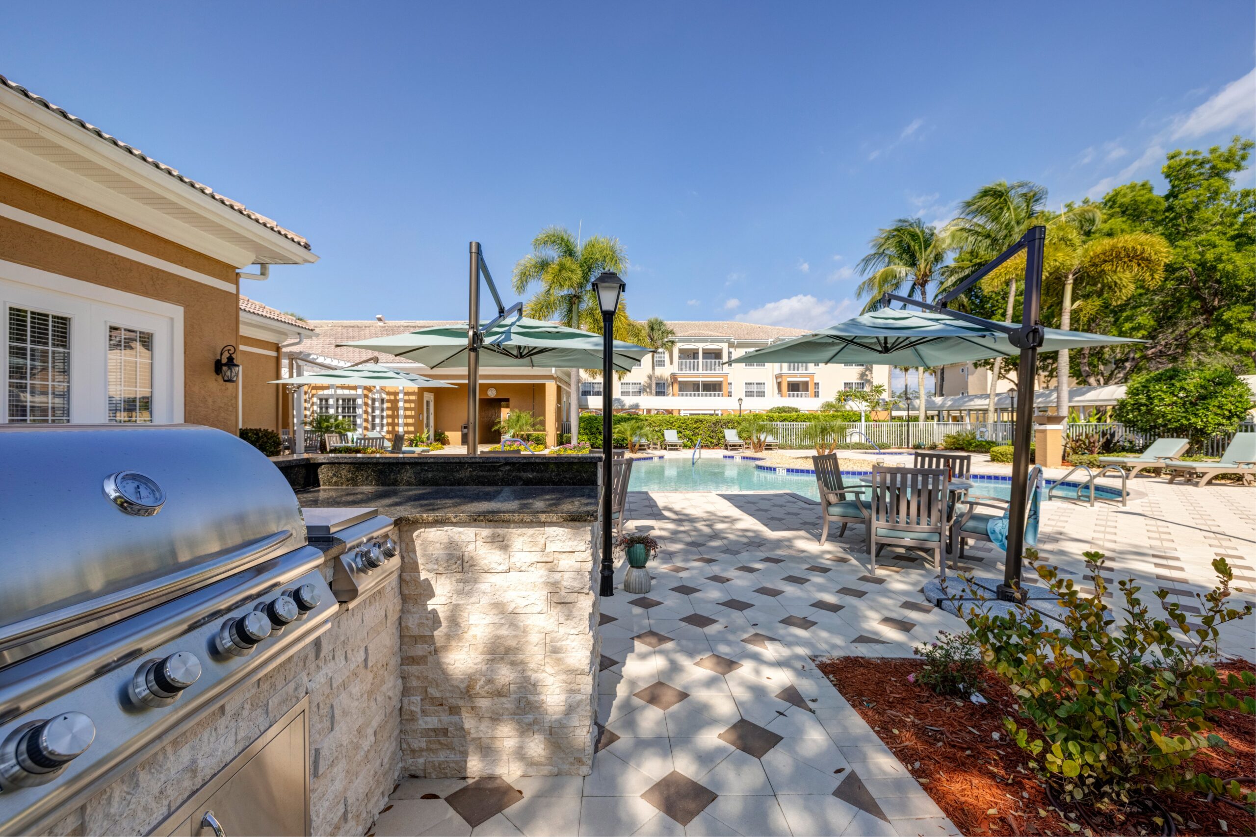 Outdoor pool area with grill and seating