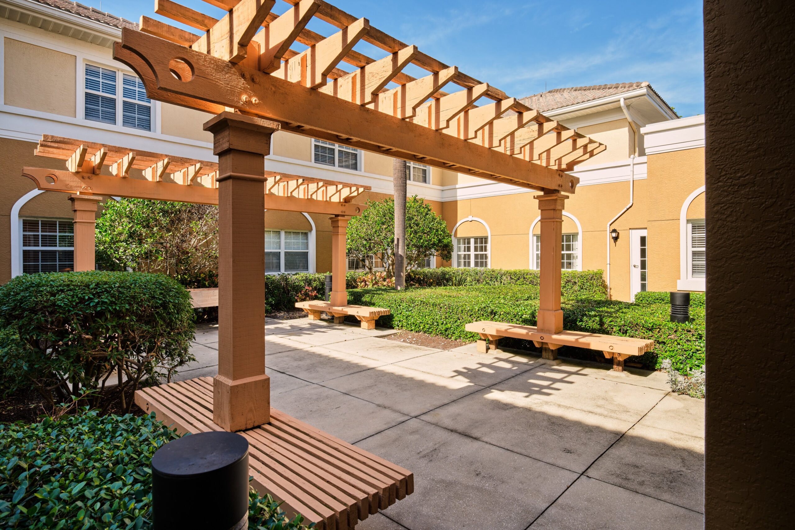Outdoor courtyard with shaded seating area and greenery