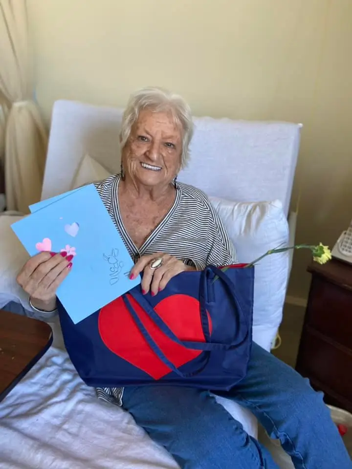 Senior resident smiling with a bag and greeting cards