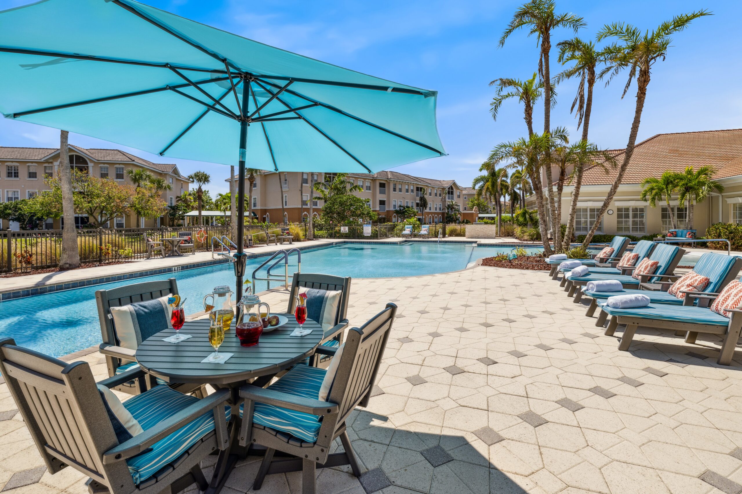 Outdoor pool area with seating and umbrellas
