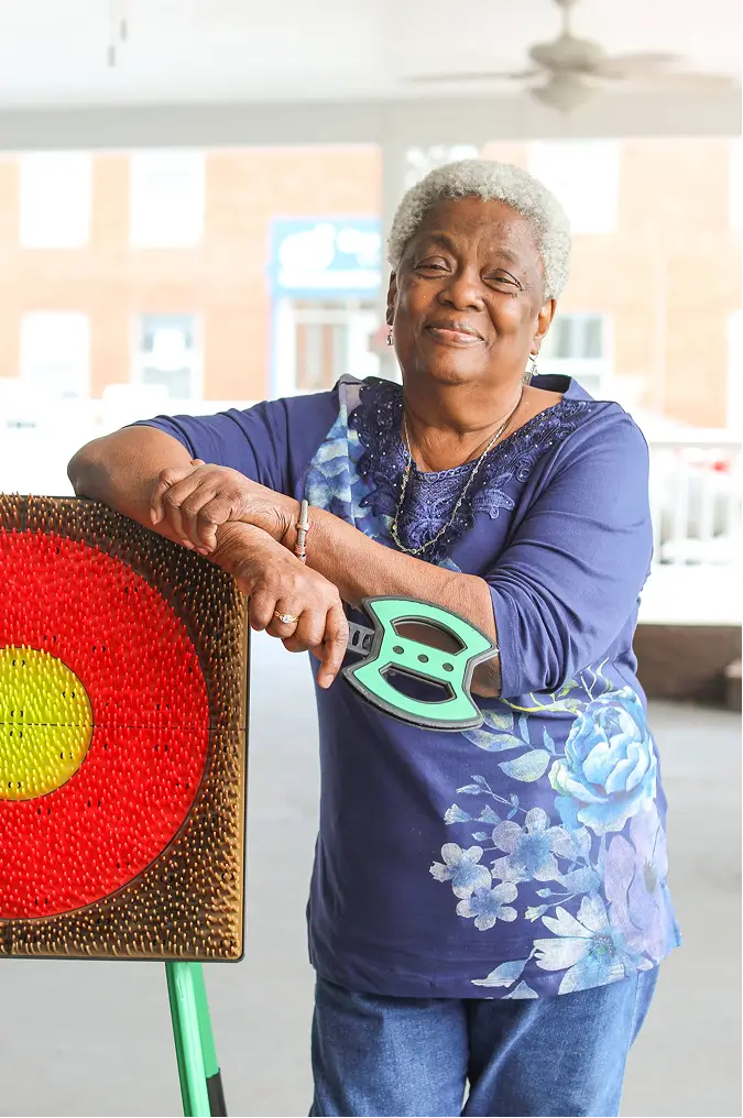 A resident posing beside an art target