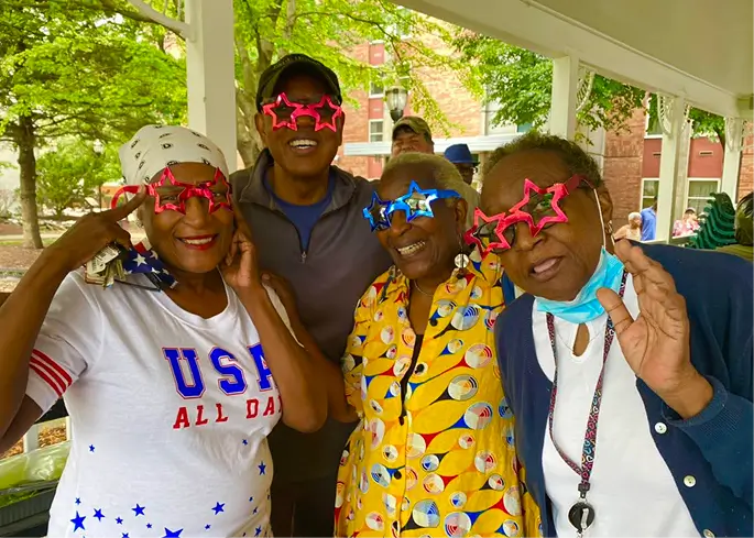 Residents enjoying a festive outdoor gathering with fun glasses