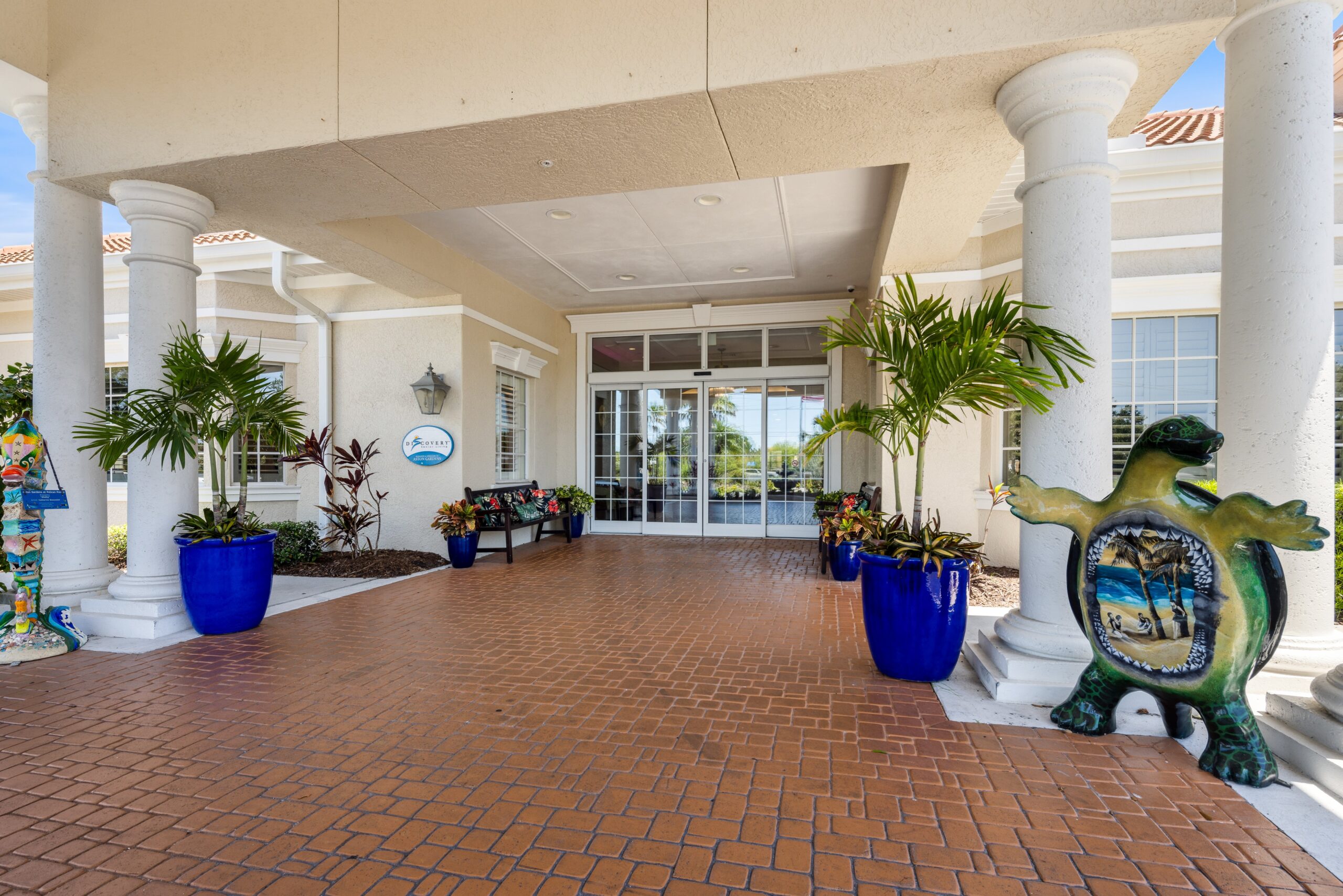 Entrance of Aston Gardens at Pelican Pointe with colorful decor