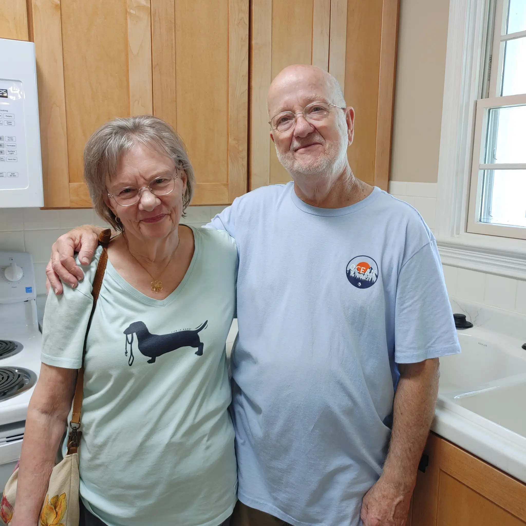 Two residents posing together in the kitchen