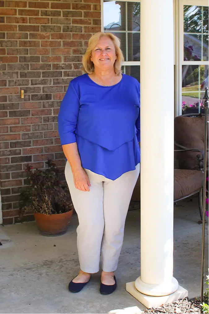 Resident posing on the porch of a senior living facility
