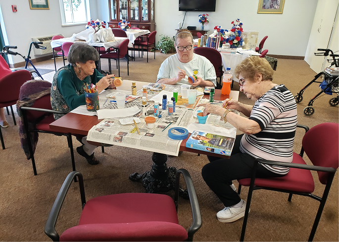 Residents engaging in a painting activity in the common area