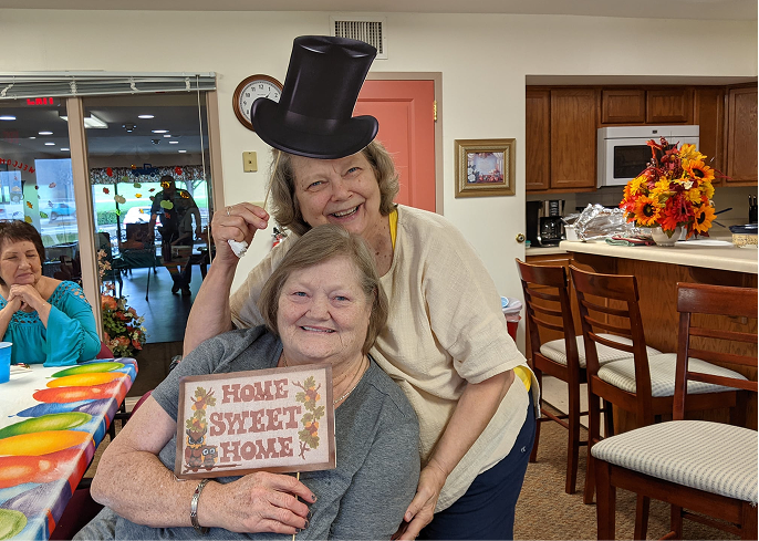 Residents celebrating with a fun sign in an activity room