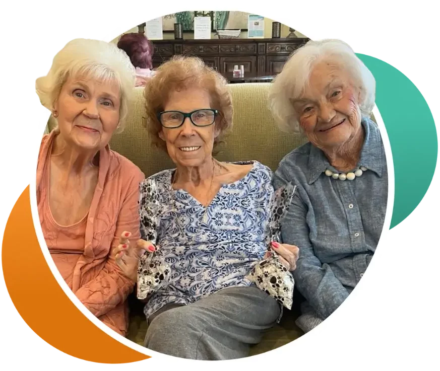Three smiling residents sitting together on a couch