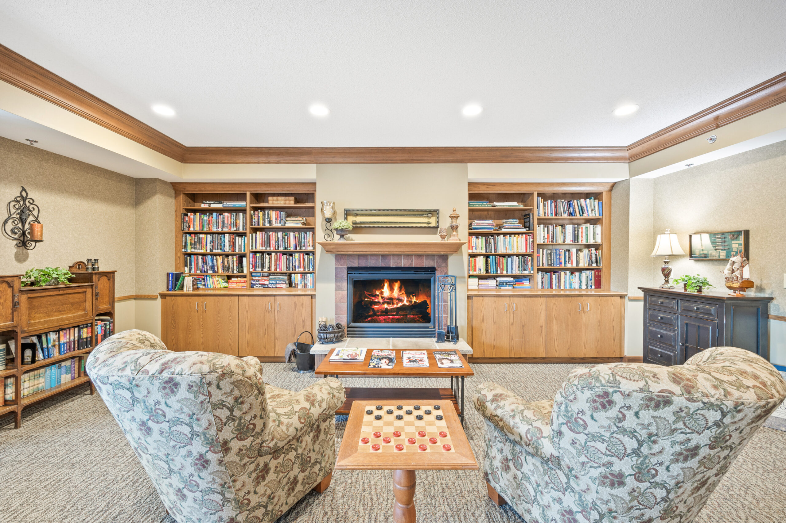 Comfortable seating area with bookshelves and a fireplace