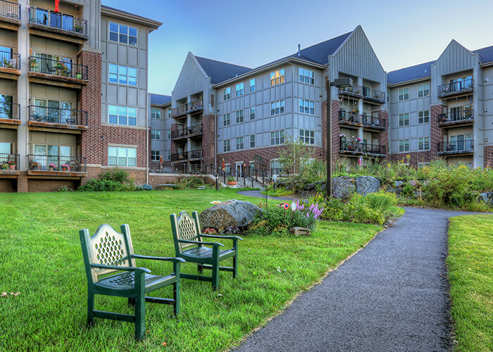 Outdoor seating area with garden and building in background
