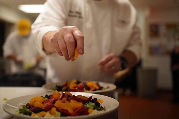 Chef preparing a fresh fruit salad in the kitchen