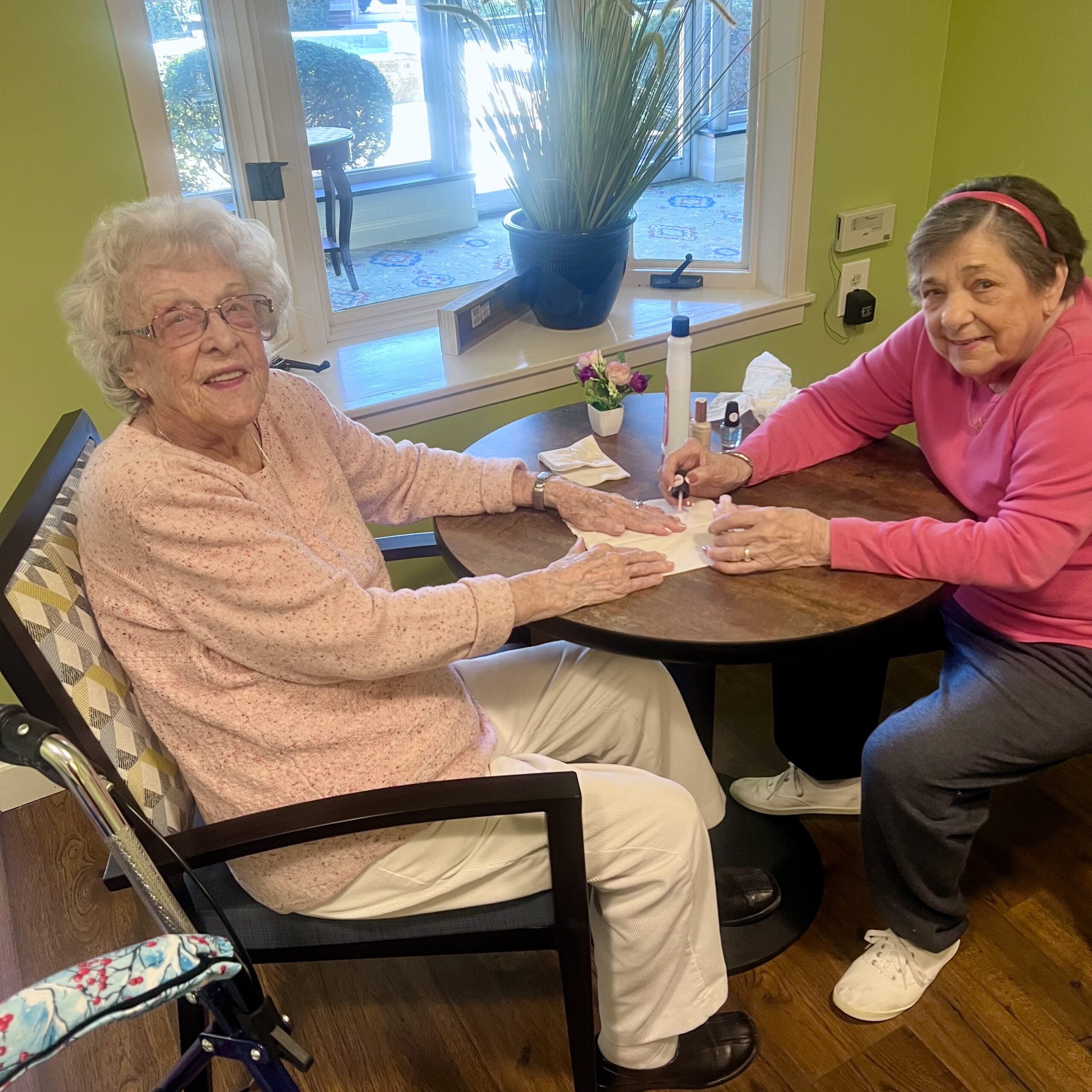 Two residents enjoying a manicure in a vibrant interior