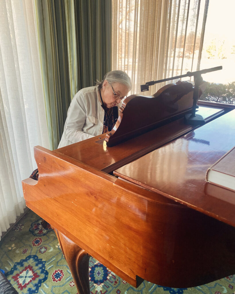 Resident playing piano in a bright room
