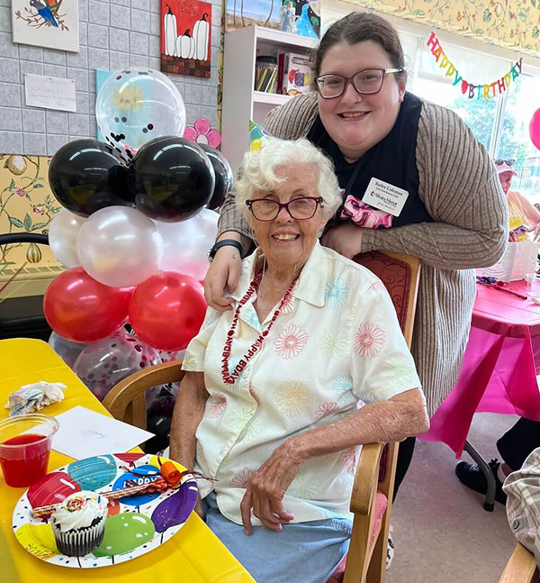 A resident celebrating with staff during a birthday party