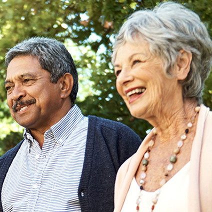 Couple walking outdoors, smiling in a garden