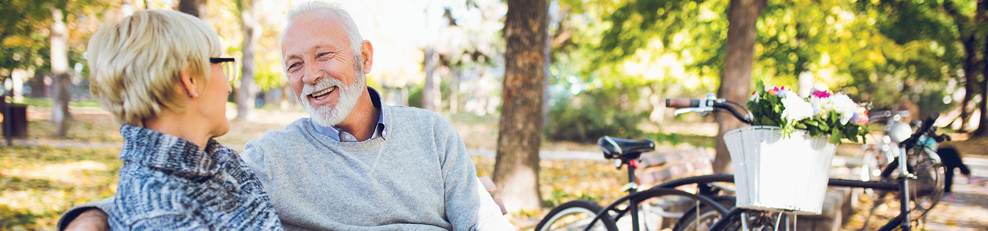 A senior couple smiling together in a park