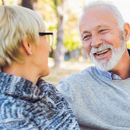 Seniors enjoying a conversation outdoors in a garden setting