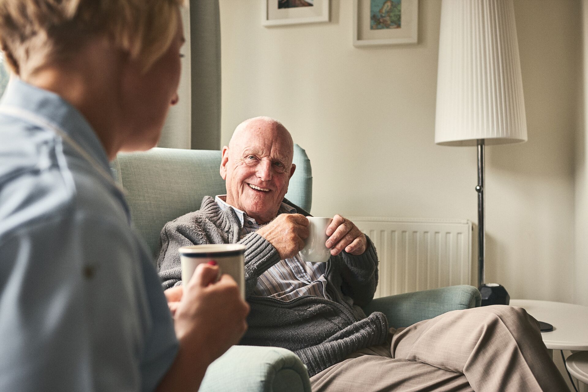 Two residents enjoying coffee in a cozy lounge