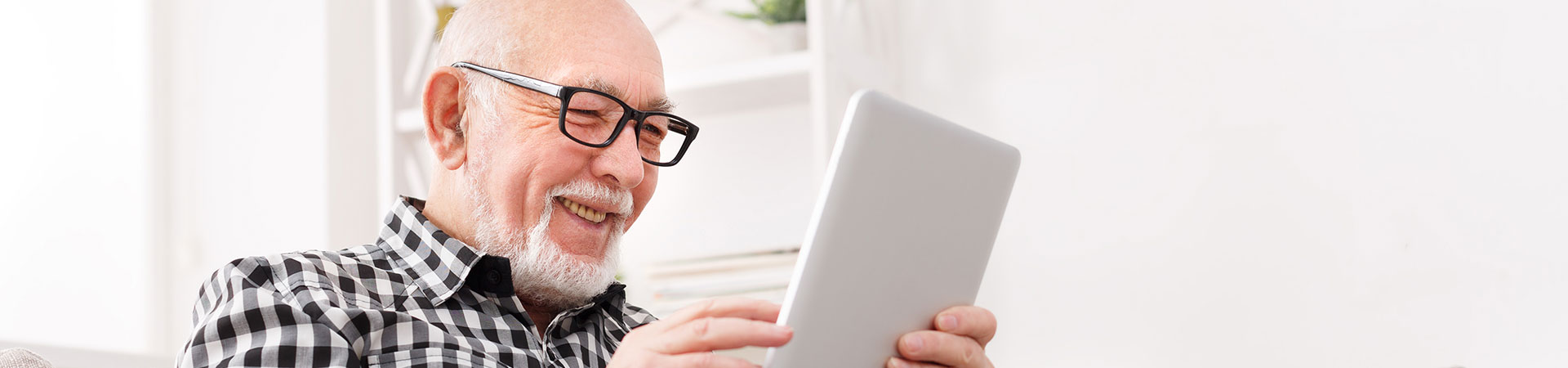 Senior man enjoying a tablet in a cozy setting